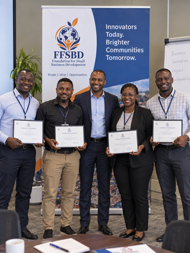 Entrepreneurs from a funded program holding their certificates together