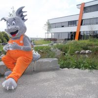 IHSE-Maskottchen Draco besichtigt die Gartenanlage