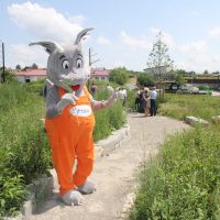 IHSE-Maskottchen Draco besichtigt die Gartenanlage